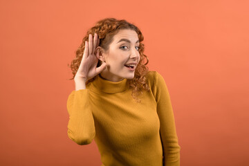 Young and attractive caucasian redhead girl holding her hand near her ear due to deafness isolated...