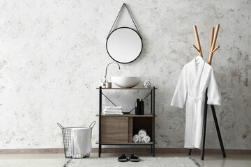 Interior of light bathroom with sink, mirror and basket