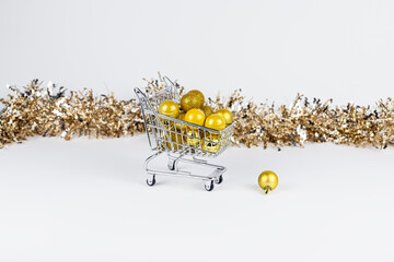 Shopping trolley full of Christmas baubles and tinsel composition.