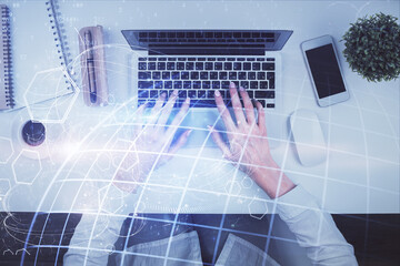 Double exposure of woman hands working on computer and world map hologram drawing. Top View. International business concept.