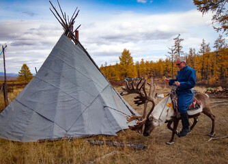 Man riding reindeer in  Mongolia. © James