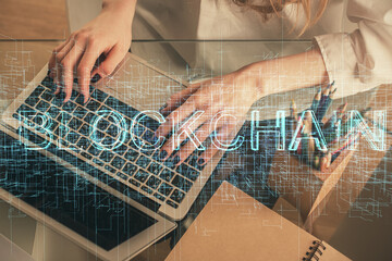 Double exposure of woman hands typing on computer and crypto market theme hologram drawing. Blockchain concept.