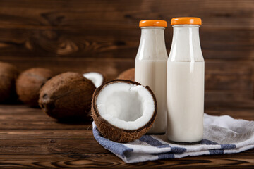 Coconut yogurt and coconuts on a wooden background. Close-up.