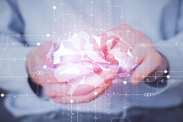 Double exposure of man's hand holding and using a digital device and brain hologram drawing. Data...