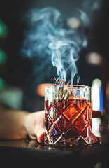 man hand bartender making cocktail in bar with smoke