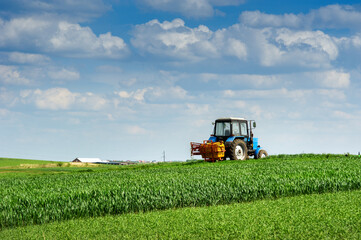 sprayer in a wheat field in the spring, the hills of agricultural land