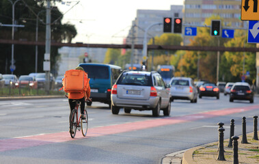 Kurier na rowerze, dostarcza jedzenie na ulicach miasta.		