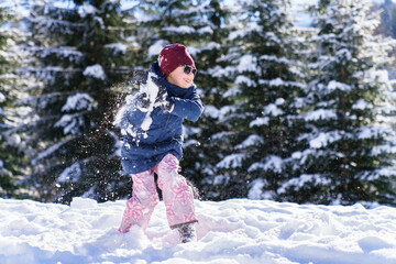 Snowball fight. Kid playing in snow on winter vacation. Child having fun