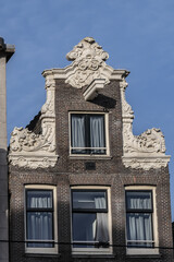 Architectural fragments of Amsterdam old historic building at Damrak avenue. Damrak is the main street in Amsterdam City Centre. Amsterdam, The Netherlands.