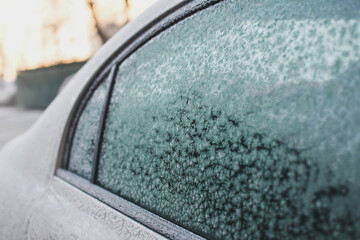 Detail of a car side window covered with heavy hoarfrost. Low DOF. Selective focus.