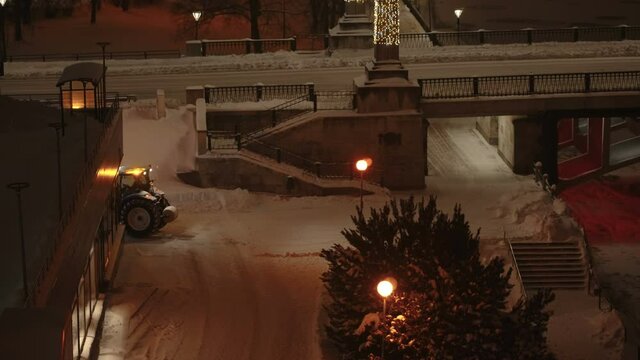 A snow plower truck clearing out the thick snow on the ground at night time in Estonia