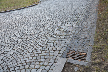 drainage of a cobbled road to the side. cobble gutter drained into a ditch or sewer. reinforced...
