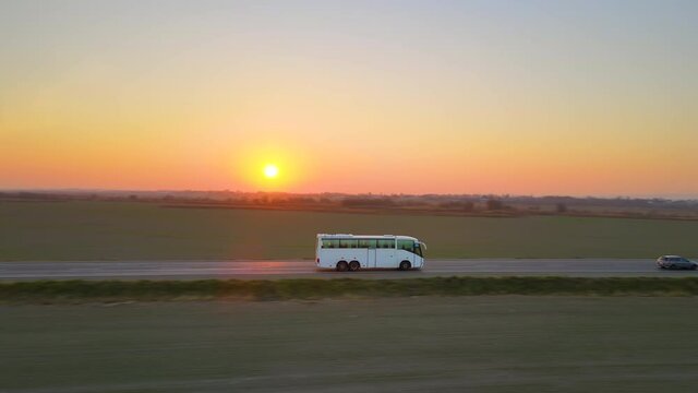 Aerial view of intercity passenger bus driving on highway in evening