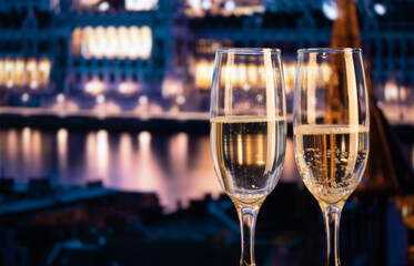two champagne glasses against fireworks in the city New Year's eve celebrations