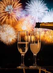 two champagne glasses against fireworks  New Year's eve celebration