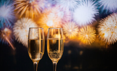 two champagne glasses against fireworks  New Year's eve celebration