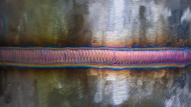 Welding of stainless steel with argon arc welding. Welding TIG. Color welding seam.