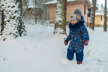 Fototapeta na wymiar little boy walk winter in the snowy forest