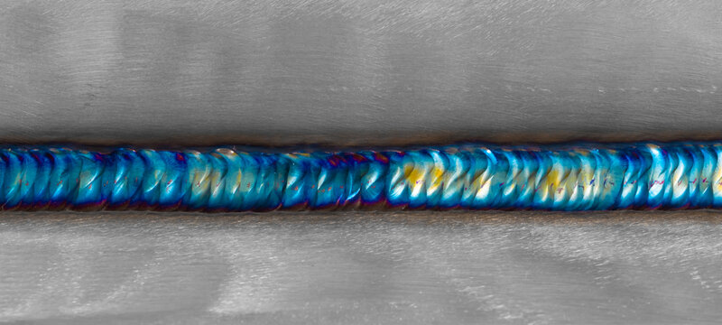 Welding of stainless steel with argon arc welding. Welding TIG. Color welding seam.