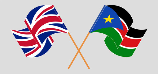 Crossed and waving flags of United Kingdom and South Sudan