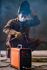 The welder welds metal structures by manual electric arc welding. MMA welding.