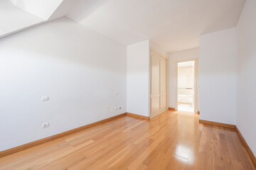 bedroom with white painted walls and wooden closet with en suite bathroom