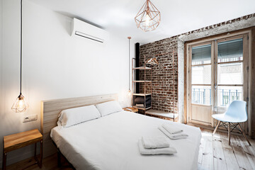 Room in modern vacation rental apartment with copper tube bookcase and wooden window on brick wall