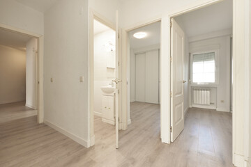 Distributor of apartment with white wood carpentry and light wood flooring