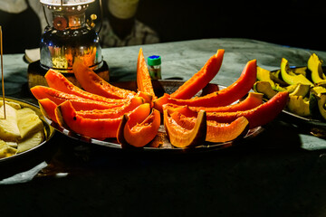 Sliced papaya fruit for sale at the Forodhani gardens in Stone town at night. Zanzibar, Tanzania