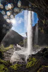 Picturesque waterfall Kvernufoss autumn view, southwest Iceland. Waterdrop and sun flares on lens.