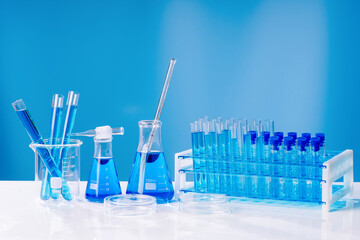 Collection of medical flasks on a blue background.Science glass flask blue chemistry laboratory banner background. Concept of medicine