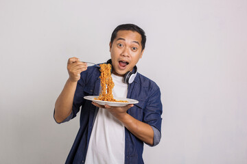 Asian man eating instant noodle and feel surprise with how delicious it is 