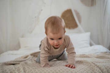 Fototapeta premium Cute toddler baby crawling on bad at home