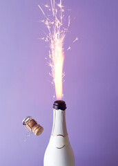 Champagne bottle with firework on a purple background. New Year surreal party and celebration...