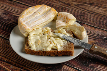 Close-up of a red smear cheese spread on a slice of whole wheat box bread.