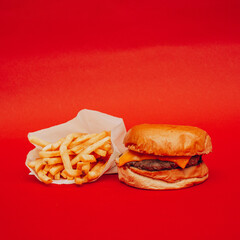 Hamburguesas con papas en un fondo pleno color rojo