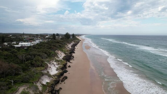 Tracking along a deserted Australian beach from above with waves crashing, Drone 4K