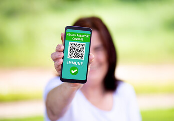 Brazilian woman holding a Smartphone with the screen displaying her digital vaccination passport. Digital certificate of vaccination against Covid-19.