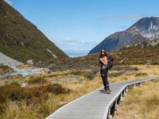 Female hiker on a wooden boardwalk on the alpine track to Mount Cook New Zealand