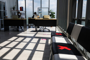 Shadow and light shot of waiting chairs in company office workplace during coronavirus quarantine pandemic outbreak marked with red cross marker sign to avoid human contact for safety social distance