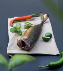 smoked mackerel fish with spices on dark stone background. Smoked fish, mediterranean food, herring fish, seafood, top view