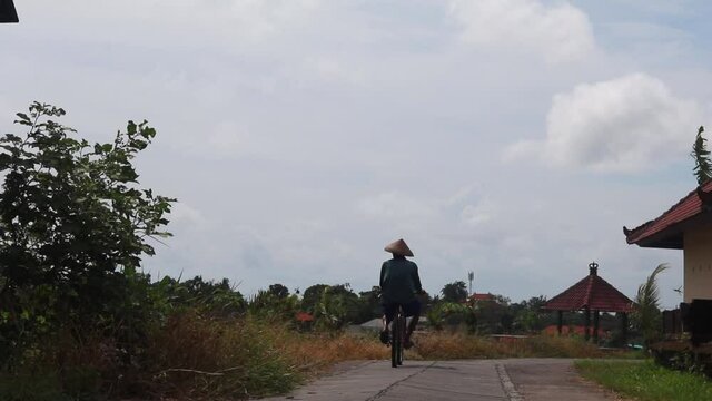 Indonesian farmer riding a bike