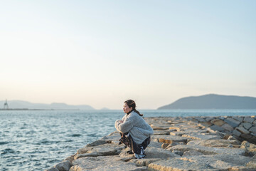 冬の夕暮れの海にいる女性