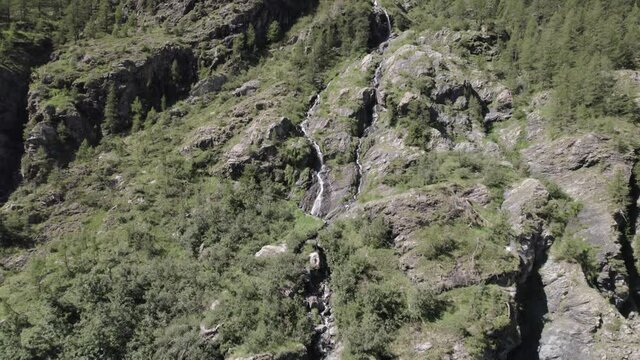 video of crane plane or ascent with drone flying over a waterfall in the italian alps