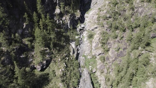 plane video with reverse description with drone flying over a waterfall in the italian alps