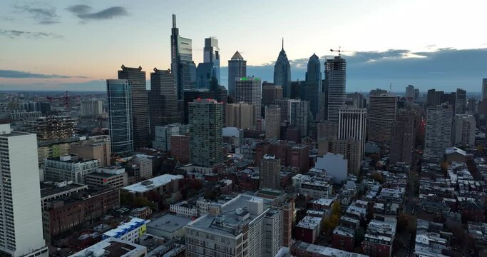 Aerial pullback shot reveals Philly skyline cityscape at dawn. Early morning evening light. Dramatic drone view.
