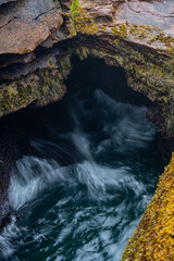 Rising tide waves crashing into a natural rock inlet called Thunder Hole in Acadia National Park,...