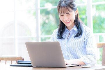 メインビジュアルにも使いやすい俯いてパソコンの仕事をする美しい日本人女性