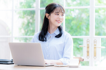 パソコンをしながら遠くを見つめる女性