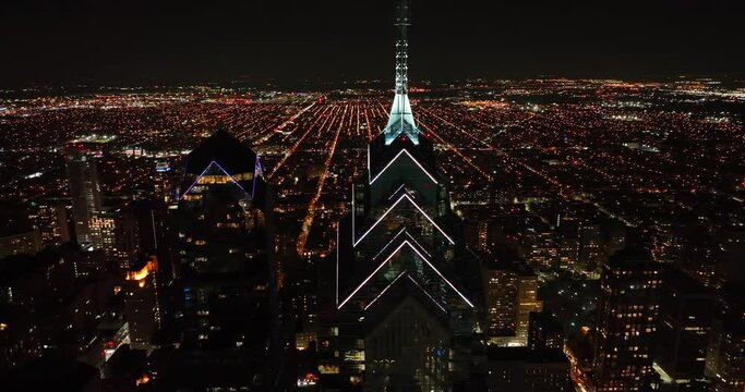 Cinematic orbit of urban skyscrapers in USA at night. Cityscape view with lights. Dramatic aerial drone view.